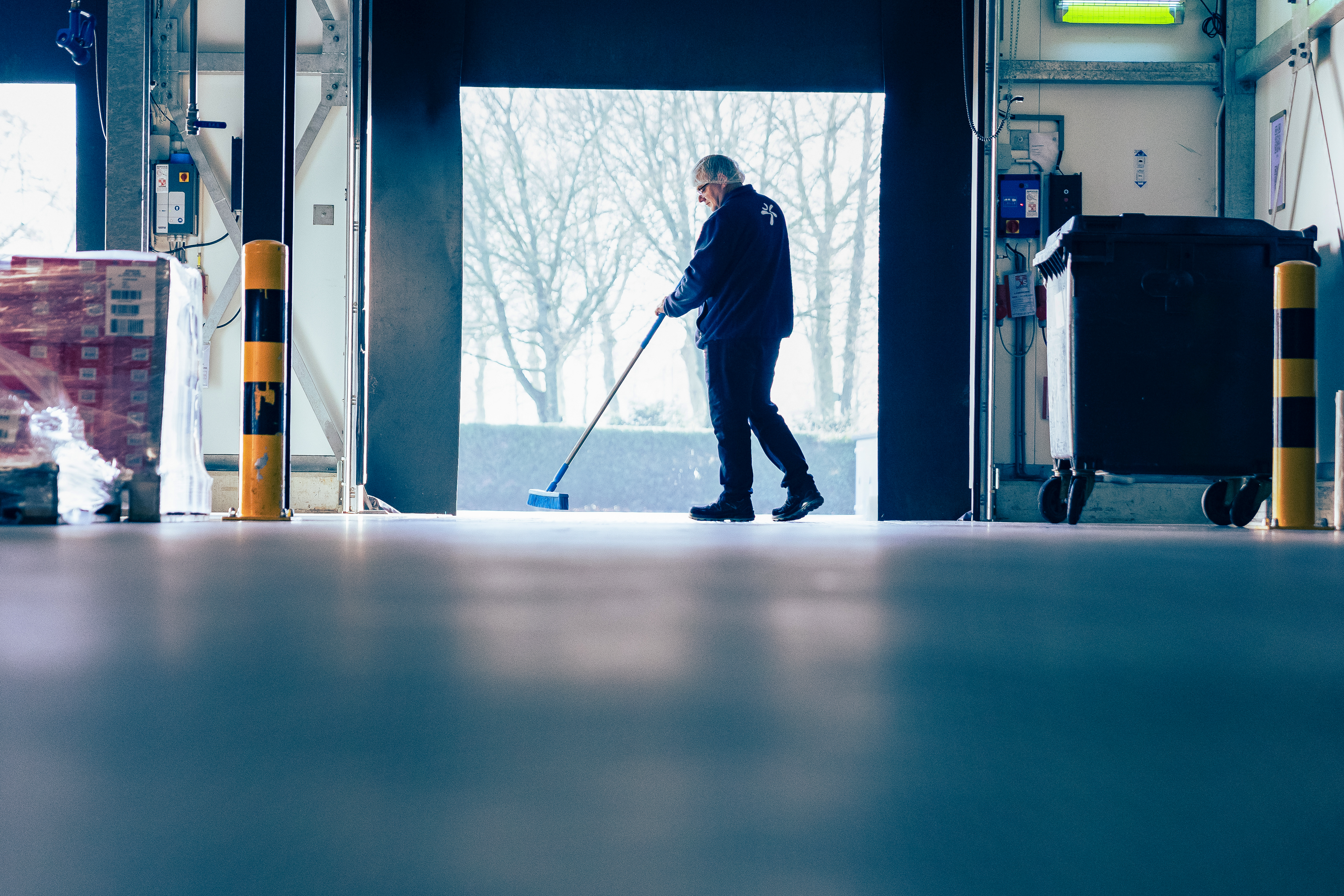 Een persoon veegt de vloer in een faciliteit in de voedingsindustrie