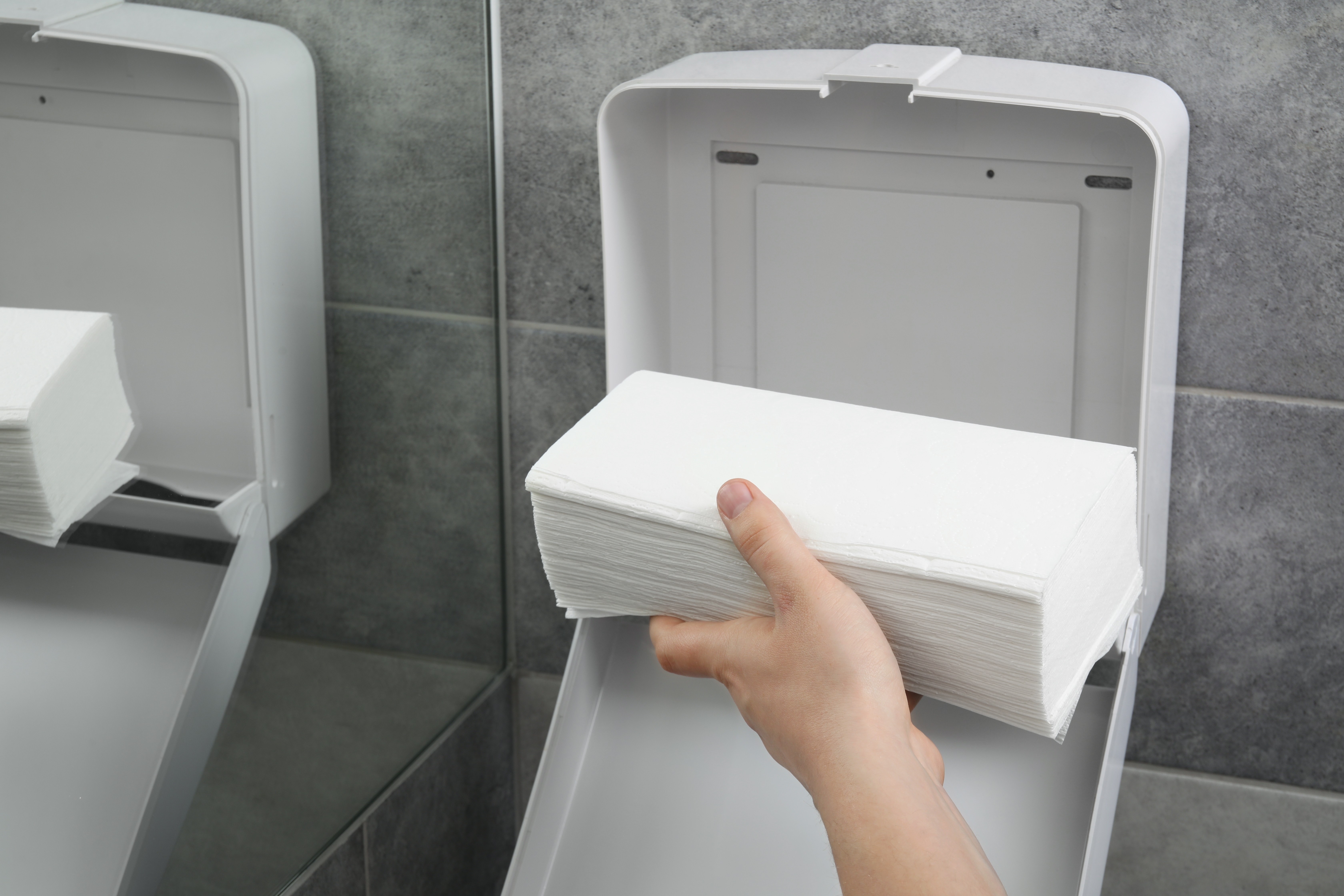 Een persoon die het afdroogpapier aanvult
