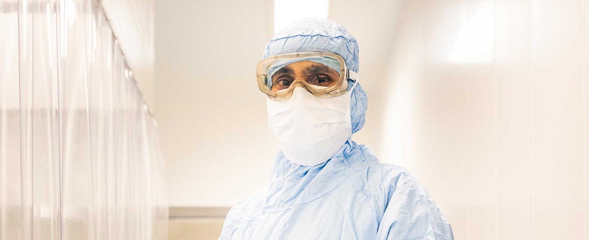 Een medewerker in een cleanroomomgeving