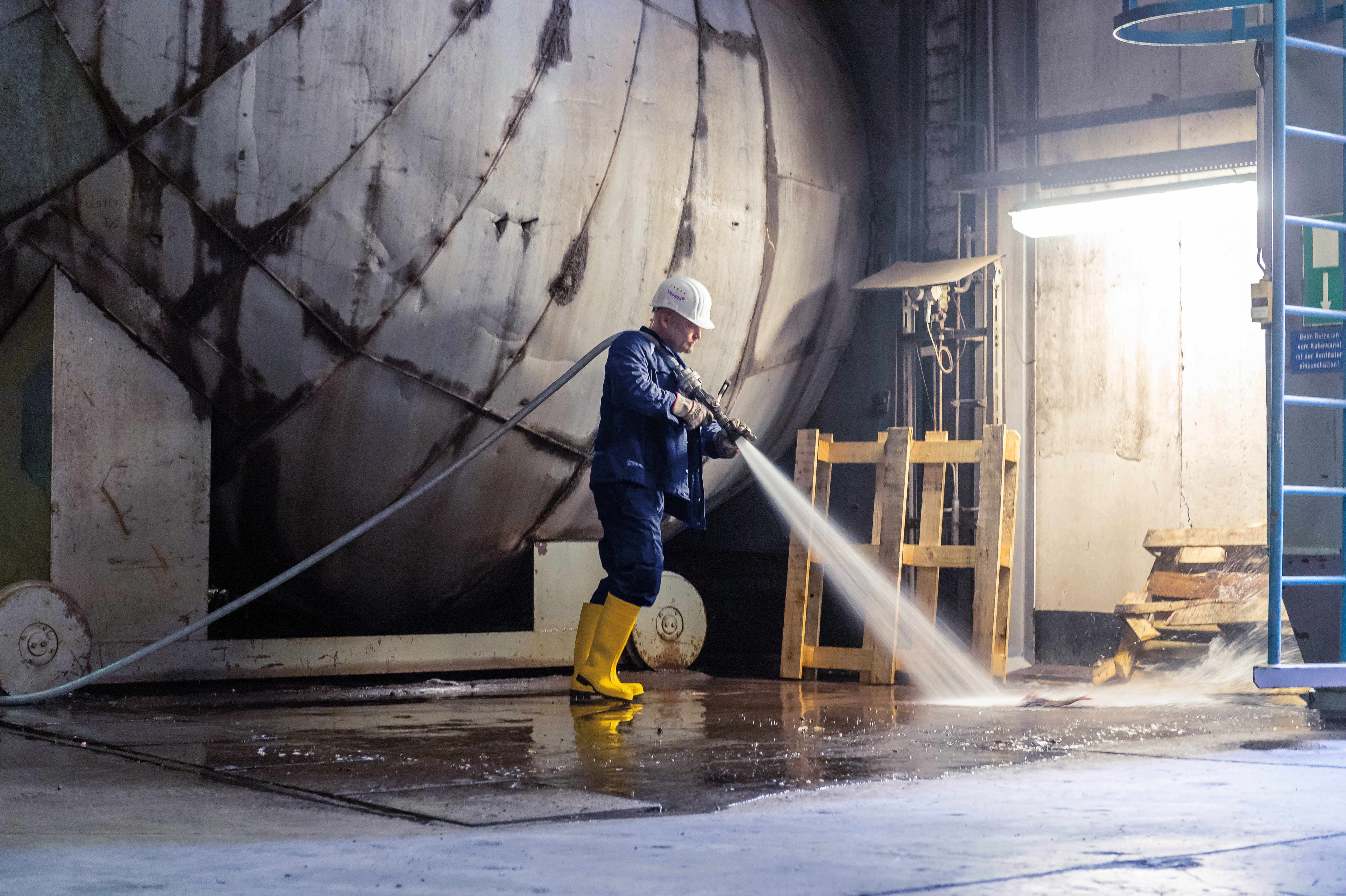 Iemand maakt een faciliteit schoon in een industriële omgeving