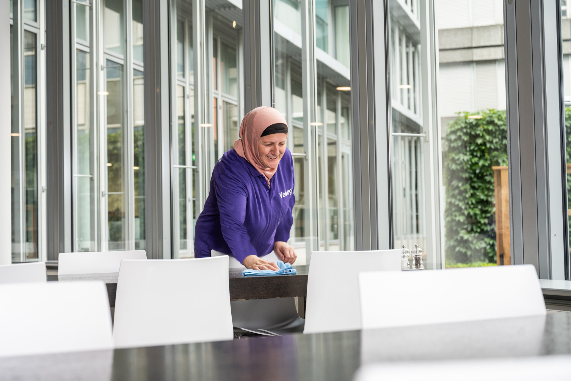 Een persoon maakt een tafel schoon in een openbare ruimte