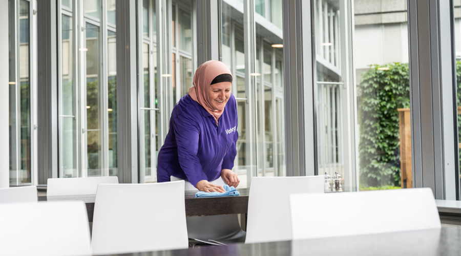 Een persoon maakt een tafel schoon in een openbare ruimte